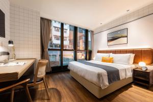香港香港中环荷李活道一尚酒店的配有一张床和一张书桌的酒店客房