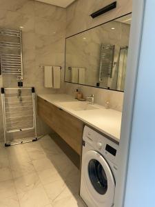 巴库Sea Breeze Apartments Lighthouse的一间带洗衣机和水槽的浴室