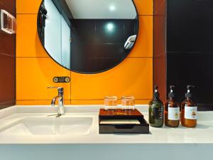 简阳南贰·街里酒店(成都天府国际机场店)的浴室水槽配有瓶装葡萄酒和镜子