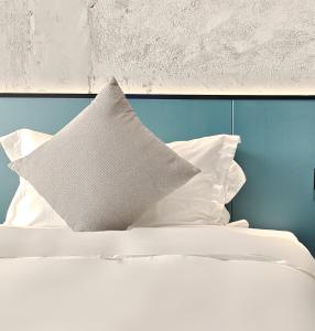简阳南贰·街里酒店(成都天府国际机场店)的一张带白色枕头和蓝色墙壁的床