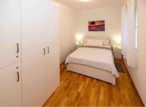 克宁Apartment Old Town - Bambo的卧室配有白色的床和白色橱柜。
