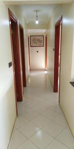 阿加迪尔Appartement agadir centre的空的走廊,有两扇门,铺着瓷砖地板