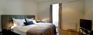 马里博尔马里博尔城市公寓酒店的一间卧室配有一张大床和电视