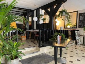 萨勒河畔巴特诺伊施塔特Hotel Café Rhönperle的一间种有植物的餐厅,一间房间里设有桌子
