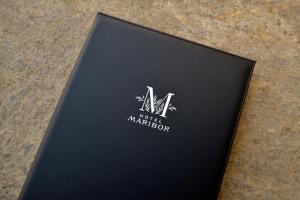 马里博尔马里博尔城市公寓酒店的坐在桌子上的一个黑书