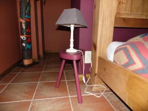 绍德方丹西城旅馆的一张紫色凳子,床边有一盏灯