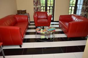 绍德方丹西城旅馆的客厅配有2把红色皮革椅子和咖啡桌