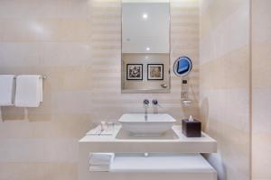 迪拜Spacious Studio Apartment in Hyatt Regency Dubai Creek Heights by the S Holiday Homes的白色的浴室设有水槽和镜子