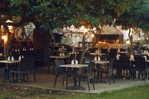 OlmicciaA Machja的树下设有桌椅的餐厅