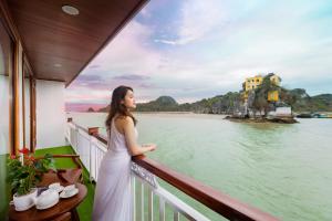 下龙湾Le Journey Calypso Pool Cruise Ha Long Bay的站在一个眺望着水面的阳台上的女人
