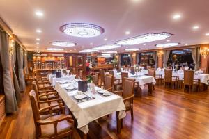 下龙湾Le Journey Calypso Pool Cruise Ha Long Bay的一间设有白色桌椅的用餐室