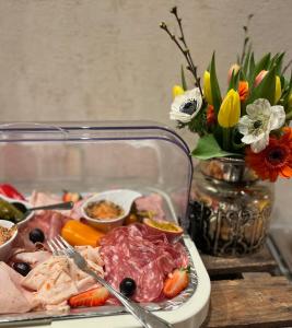 弗雷兴Hotel Haus Loewe的盘子,盘子上放着肉,蔬菜和鲜花