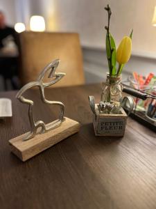 弗雷兴Hotel Haus Loewe的鸟的小象,桌子上的花瓶
