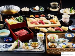 函馆La Vista Hakodate Bay Annex的配上寿司和其他食物的桌子