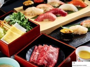 函馆La Vista Hakodate Bay Annex的餐桌上摆放着带寿司的食品盘
