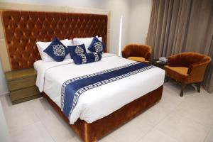 伊斯兰堡Trivelles Executive Suites Islamabad的一间卧室配有一张带蓝白色枕头的大床