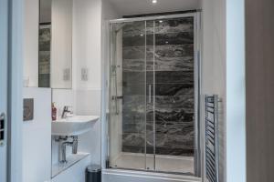 BuckinghamshirePenthouse-Central-Free parking的一间带玻璃淋浴和水槽的浴室
