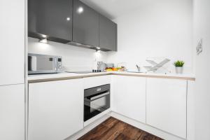 伯明翰Luxury Birmingham City Centre Apartment - Top Rated - 318H的白色的厨房配有白色的橱柜和微波炉