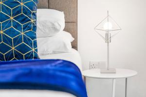 伯明翰Luxury Birmingham City Centre Apartment - Top Rated - 318H的一间卧室配有一张蓝色的床和一张带台灯的桌子