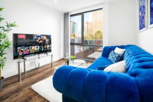 伯明翰Luxury Birmingham City Centre Apartment - Top Rated - 318H的客厅设有蓝色沙发,配有电视