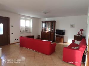 BrembillaCasa "La Forcella"的客厅配有2张红色沙发和电视