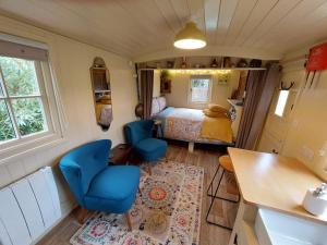 伍勒The Humble Hut的一间小卧室,配有床和蓝色的椅子