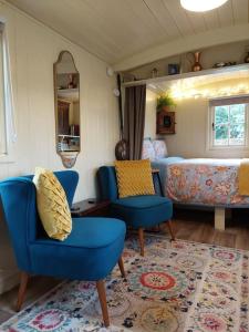 伍勒The Humble Hut的客厅配有蓝色椅子和沙发