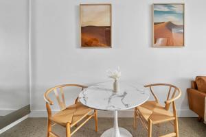 悉尼Modern Studio Retreat in Crown St with AirCon的一间带桌子和两把椅子的用餐室