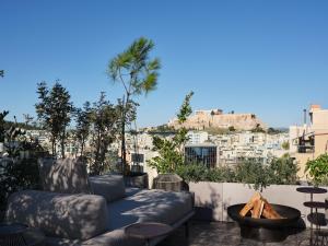雅典Monastik Living in Athina的带沙发的庭院,享有城市美景