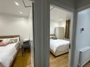 LewishamBeautiful Double Room with Free Wi-Fi and free parking的一间小卧室,配有两张床和镜子