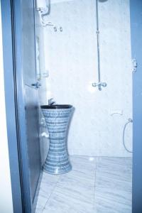 松盖阿Bwawani Gardens的浴室设有蓝色和白色的花瓶淋浴。