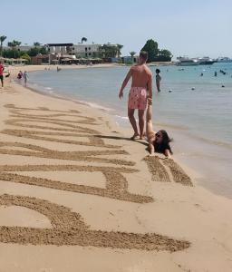 赫尔格达Eagles Paradise Abu Soma Resort的沙滩上玩耍的男人和女人