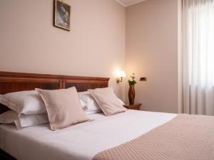 圣乔瓦尼·罗通多Hotel SAN PIO的一间卧室配有带白色床单和枕头的床。