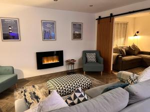 霍利黑德Stylish Modern Home with Parking Enclosed Garden的带沙发和壁炉的客厅