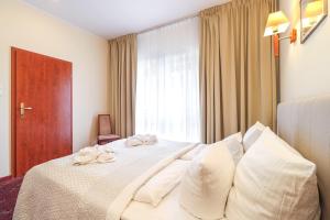 斯维诺乌伊希切Atol Spa的卧室配有带白色枕头的床和窗户。