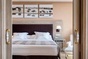 赫雷斯-德拉弗龙特拉巴瑟罗蒙蒂卡斯提罗高尔夫酒店的卧室配有带白色枕头的大床