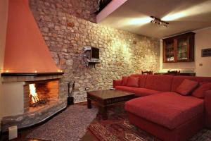 维蒂纳Αέσκω的客厅设有红色的沙发和壁炉