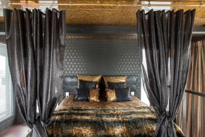 阿姆斯特丹阿姆斯特丹法拉达起重机酒店的一间卧室配有一张带黑色窗帘的床