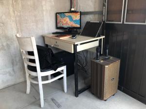 胡志明市Cactos Bar & Homestay的一张桌子,上面有一台电脑,椅子上还有一台电脑