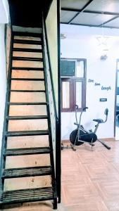 新德里Rooftop Floor with a big Room的通往带健身房的房间的楼梯