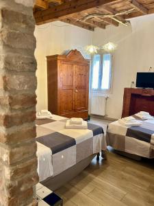 费拉拉Green Rooms Ferrara的一间卧室设有两张床和石墙