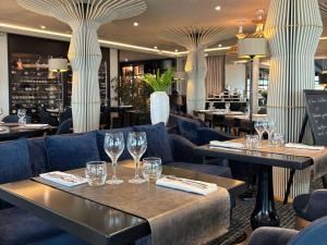 沙特拉永普拉日La Grande Terrasse Hotel&Spa La Rochelle MGallery Hotel Collection的餐厅设有2张桌子和椅子,配以酒杯