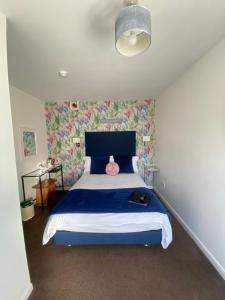 切达Gordons的一间卧室配有一张蓝色的床和粉红色枕头