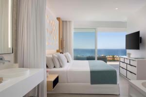 阿德耶Royal Hideaway Corales Suites的一间卧室配有一张床,享有海景