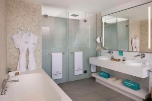阿德耶Royal Hideaway Corales Suites的带浴缸、水槽和镜子的浴室