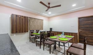 钦奈Treebo Trend Eco Stay T Nagar的一间带桌椅和吊扇的用餐室