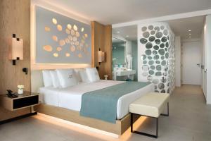 阿德耶Royal Hideaway Corales Beach - Adults Only的一间带白色大床的卧室和一间浴室