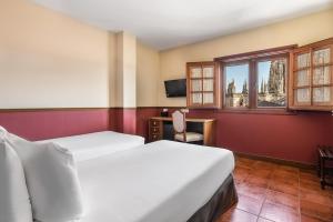 布尔戈斯Crisol Mesón del Cid的酒店客房设有两张床和窗户。
