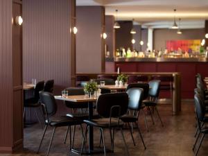 珀斯Mercure Perth On Hay的一间带桌椅的餐厅和一间酒吧