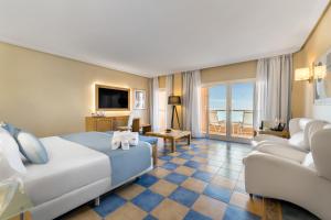 卡勒达德福斯特Elba Sara Beach & Golf Resort的酒店客房,配有床和沙发